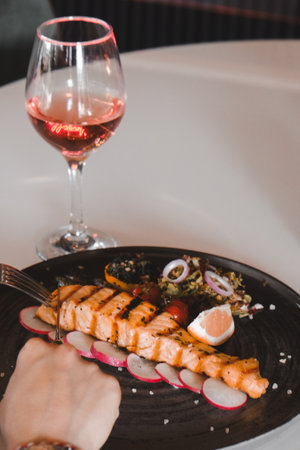 Fried sea bream fish on white plate with onion, garden rocket and lemon slicesの写真素材