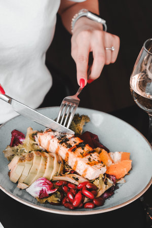 Fried sea bream (cupra) fish on white plate with onion, garden rocket and lemon slicesの写真素材