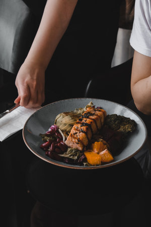 Fried sea bream fish on white plate with onion, garden rocket and lemon slicesの写真素材
