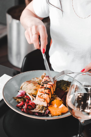 Fried sea bream fish on white plate with onion, garden rocket and lemon slicesの写真素材
