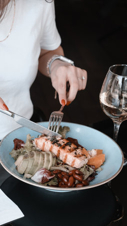 Fried sea bream fish on white plate with onion, garden rocket and lemon slicesの写真素材