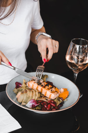 Fried sea bream fish on white plate with onion, garden rocket and lemon slicesの写真素材