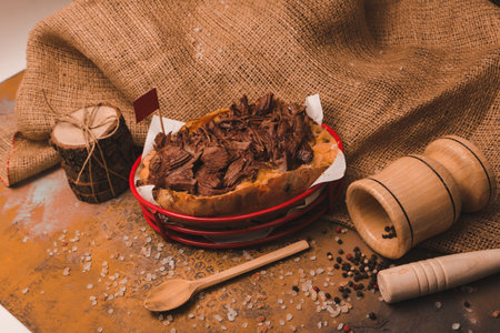 Baked kumpir potato stuffed with the cheese, sausage, olives, peppers and cornの写真素材