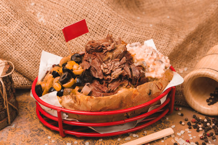 Baked potato stuffed with the cheese, sausage, olives, peppers and cornの写真素材