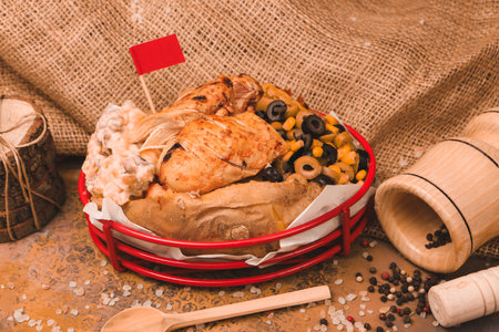 Baked kumpir potato stuffed with cheese, sausage, olives, peppers and cornの写真素材