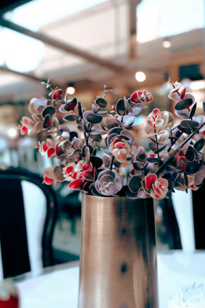 Artificial flowers in a vase on a table in a restaurantの写真素材