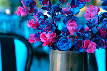 Colorful flowers in vase on the table in the cafe.