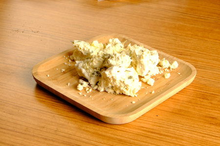 Cream cheese on a wooden plate on a wooden table, closeup of photoの写真素材