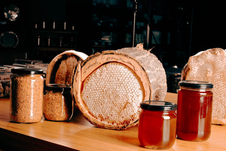 Honeycombs and jars with honey on a wooden table.
