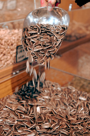 A closeup shot of a spoonful of sunflower seeds in a shop