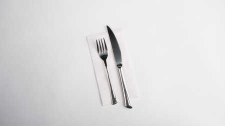 Fork and knife on a napkin isolated on a white background