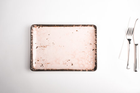 Empty ceramic plate, fork and knife on white background, top viewの写真素材