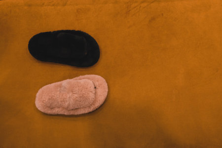 A pair of slippers on an orange background with space for textの写真素材