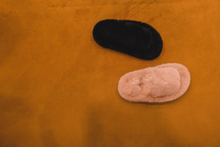 Pair of slippers on orange background. Top view with copy space
