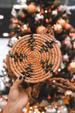 cropped view of woman holding straw bag on christmas tree backgroundの写真素材