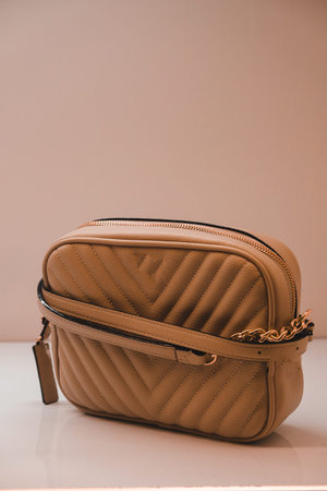 Fashionable women's leather clutch on a beige background.の写真素材