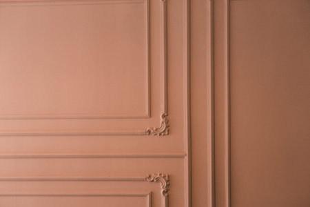 Texture of a brown wall with moldings and a decorative element.