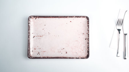 Empty ceramic plate with fork and knife on white background, top viewの写真素材