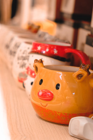 Colorful ceramic cups on a wooden shelf.の写真素材