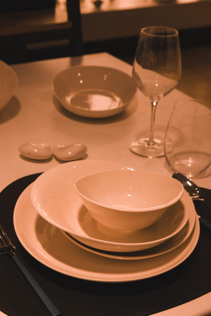 Table set for dinner in a restaurant, closeup of plates and glasses