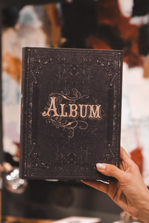 Close-up of an antique book in the hands of a woman