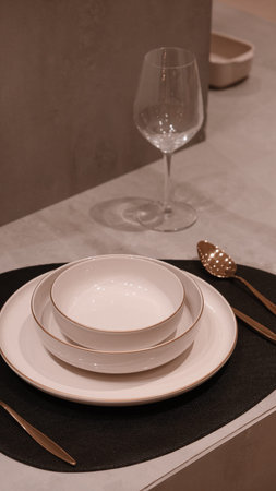 Table setting in the modern dining room. White plates and cutlery.