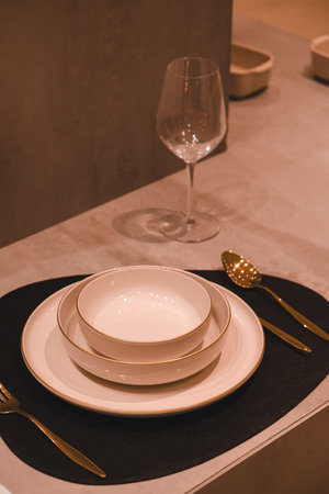 Set of white porcelain plates and cutlery on black table in restaurantの写真素材