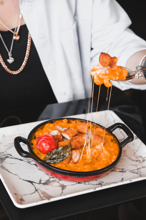 Chef in a white shirt is holding a bowl of soupの写真素材