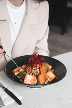 cropped view of woman eating a meal with arugula in restaurantの写真素材