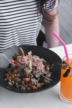 Close up of mixed vegetable salad served in black plateの写真素材