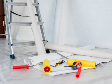 Concept of wallpapering in the house. Close-up tools for wallpapering lie on the floor.