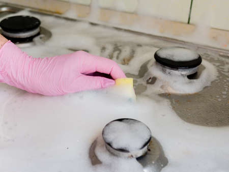 A woman washes the gas stove with a washcloth.の写真素材