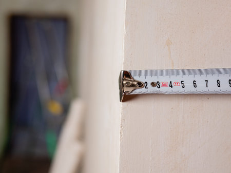 Close-up of a tape measure and pencil in womens hands. Measuring the walls in a room. Repairs in the...