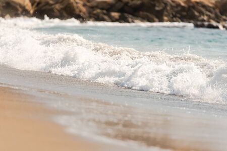 Mediterranean surf. Small waves roll on the shore. Sea foam on the beach.の写真素材