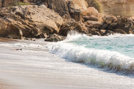 Mediterranean surf. Small waves roll on the shore. Sea foam on the beach.の写真素材