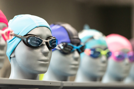 Moscow, Russia, August 24, 2019. Swimming goggles. Selection of glasses on mannequins in the store. Colorful accessories for swimming.のeditorial素材