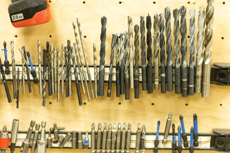Set of drills. Magnetic wall in the workshop. A lot of tips for drills and screwdrivers.
