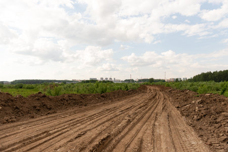 Rural road through a field. The builders laid a temporary road.