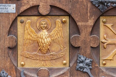 Door with a bas-relief in the Basilica of Brno. Bas-relief of a bird with a human head.の写真素材