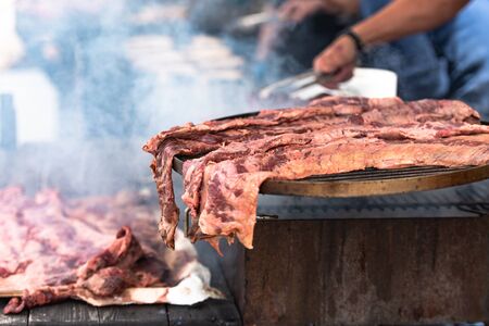 Cooking delicious meat. Italian chefs prepare treats for a large company. Large pieces of grilled meat.の写真素材