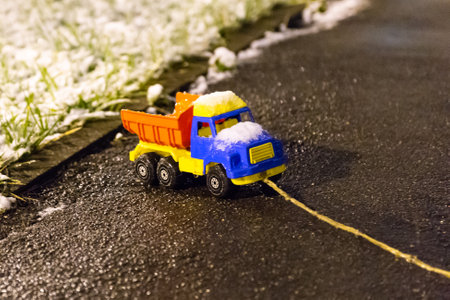 Children's car carries snow. The toy truck is covered with snow and ice.の写真素材