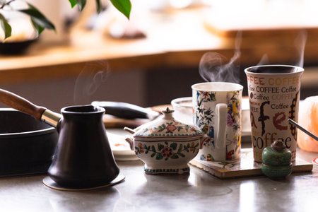 Morning coffee on the table. Turk with prepared coffee and mugs. Steam over mugs, still life on the table.の写真素材