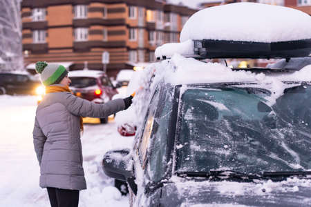 Moscow. Russia. Winter 2020. The driver clears the car of snow. During a heavy snowfall in Moscow.のeditorial素材