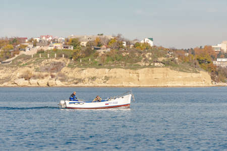 Fishermen on a boat return home. Fishing boat returns to the bay.のeditorial素材