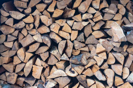 Stacked stack of firewood. Large woodpile with chopped wood. Stacked stack of firewood from the end.の写真素材