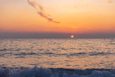 Yellow sunset from the low sun. Seashore with a sunset path on the waves.の写真素材