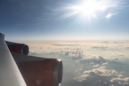 Photo from the window of the plane. Bright sun in the window in the early morning. Two engines and...