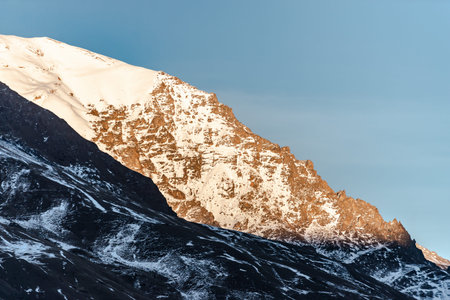 Elbrus region in the sunlight. A very large mountain in the light of the setting sun.