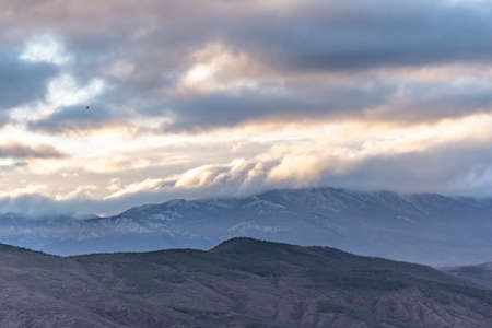 Southern coast of Crimea at sunset in winter. Sunset rays of the sun break through the clouds. Mountains, coast and beautiful scenery.の写真素材