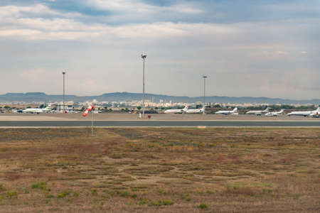 Paphos Airport in Cyprus. Planes on the runway and at the hangars. Acceleration strip with wind indicator.のeditorial素材